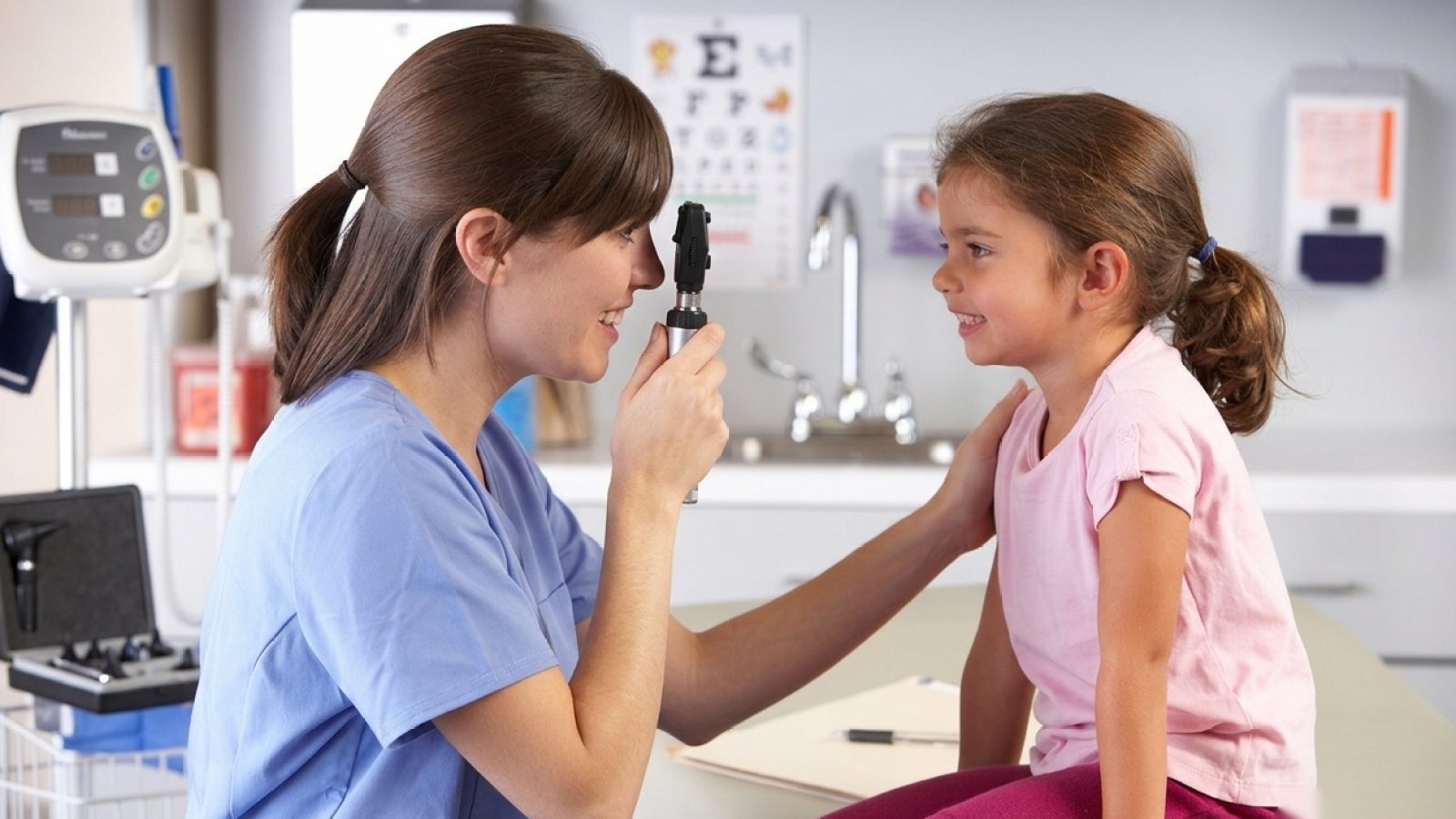 Profissional de saúde examinando criança em consultório pediátrico